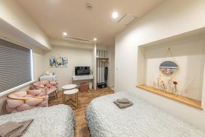 東京にあるInn The Omotesandoのベッドルーム1室(ベッド2台付)、リビングルームが備わります。