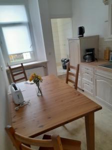 a kitchen with a wooden table with flowers on it at 70 qm Ferienwohnung mit 2 Schlafzimmern in Zwickau