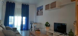 a living room with a couch and a television at Carboneras, la Mar Divina in Carboneras