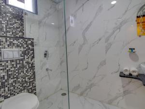 a bathroom with a glass shower with a toilet at Jasoda Heritage By Keshav Global Hotels in Jaipur