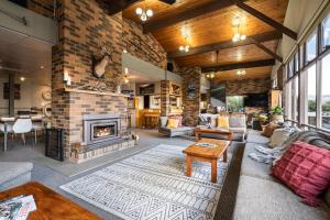 a living room with a fireplace and a brick wall at Myee Alpine Retreat in Mount Beauty