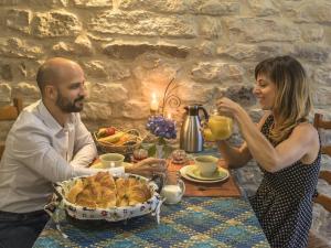 un hombre y una mujer sentados en una mesa con una cesta de comida en Guestroom Le Clerjus, 1 pièce, 2 personnes - FR-1-589-532, en Le Clerjus