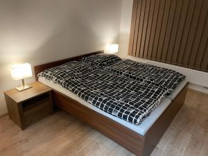 uma cama num quarto com duas lâmpadas em Apartmán za kostelem Čeladná em Čeladná