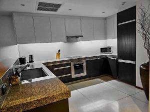 una cucina con lavandino e piano cottura forno superiore di Beachfront 2 BR Luxury Apartment Chava Surin a Surin Beach