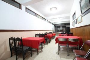 uma sala de jantar com mesas e cadeiras vermelhas em RedDoorz @ Mantrijeron 2 em Yogyakarta