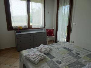 - une chambre avec un lit, une commode et des fenêtres dans l'établissement Appartamento Verdi Colline, à Moniga del Garda
