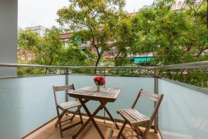 巴塞隆納的住宿－Navas 2，树木繁茂的阳台配有一张桌子和两把椅子