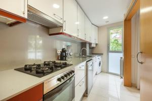 a kitchen with white cabinets and a stove top oven at Navas 2 in Barcelona