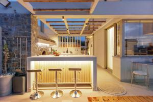 Arte Casa Luxury Resort في Prasás: مطبخ مع بار مع الكراسي حوله