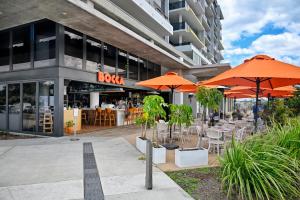 a restaurant with orange umbrellas in front of a building at Stylish, Beachside 4 b/r Dream Home - 8 guests ZD7 in Kawana Waters