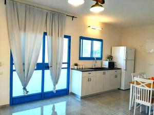 a kitchen with a large window and a refrigerator at Bein Tavor Lekineret- quiet cabin in Neve Ilan in Sede Ilan