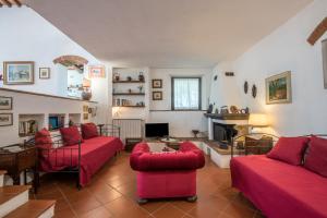 - un salon avec des canapés rouges et une cheminée dans l'établissement Villa Il Poggio di San Gimignano, à Borgatello