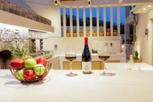 a table with two glasses of wine and a bowl of fruit at Arte Casa Luxury Resort in Prasás