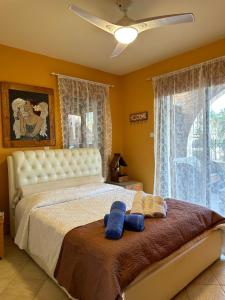 a bedroom with a large bed with blue pillows on it at Sotira Agia Napa Luxury House in Ayia Napa