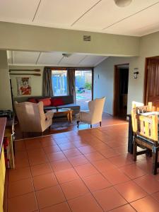 a living room with a couch and chairs at Tuinhuis in Oudtshoorn
