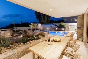 un patio con mesa, sillas y piscina en Arte Casa Luxury Resort, en Prasás