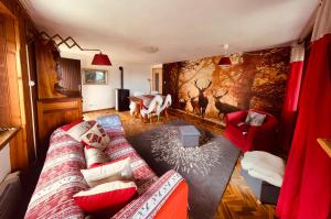 un soggiorno con divano e mobili rossi di Alpine Majestic Escape - Balcone sulle Piste di Sci a Champoluc