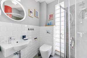 a bathroom with a sink and a toilet and a mirror at Riviera Gdańsk Brzeźno in Gdańsk