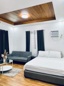 sypialnia z łóżkiem i kanapą w obiekcie Chill'n Tagaytay w mieście Tagaytay