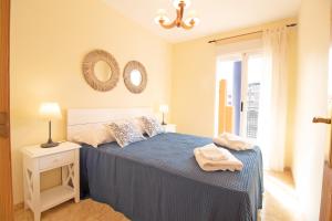 a bedroom with a bed and two mirrors on the wall at Global Properties, Apartamento con piscina y terraza en Canet playa in Canet de Berenguer +52 photos