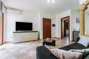 een woonkamer met een bank en een tv bij Villetta Gio in Olìa Speciosa