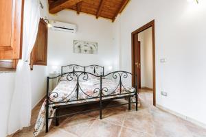 1 dormitorio con 1 cama de hierro forjado en Villetta Gio, en Olìa Speciosa