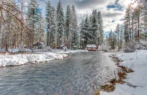 a river in the snow with a cabin in the background at Metolius Cabin 1 in Camp Sherman +6 photos