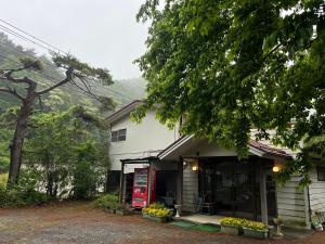 a house with a red fire truck in front of it at Narusawaso in Narusawa