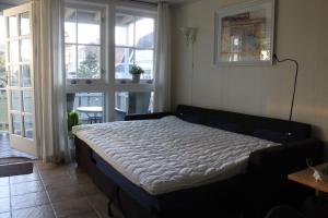 een slaapkamer met een bed in een kamer met ramen bij Bergland 10 - close to the center of Kragerø in Kragerø