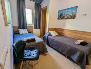 a room with two beds and a chair in it at Dalt Vila Salou in Salou