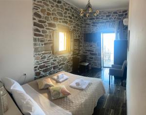 ein Schlafzimmer mit einem Bett und einer Steinmauer in der Unterkunft Castle Rizaraki in Kokkala