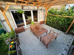 a patio with wooden tables and chairs and a wooden pergola at Ferienwohnung im Stadtzentrum von Bernau - Komfortable Wohnung mit 2 Zimmern, Bad, Spülmaschine, Waschmaschine, komplette Küche, WLAN, Terrasse, ruhige Lage in Bernau bei Berlin