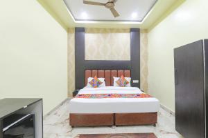 - une chambre avec un lit et une télévision dans l'établissement FabExpress GS Residency, à Varanasi