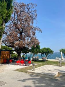 a park with red tables and chairs and a tree at Seaside apartments in Kaštela