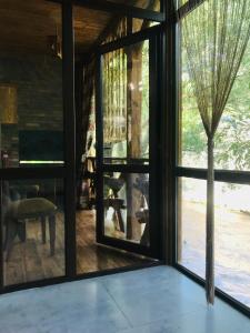 una stanza con ampie finestre e un tavolo con una pianta di David guest house LOFT Коттеджи на берегу реки a Dilijan