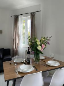 uma mesa de jantar com pratos e um vaso de flores em Seaside apartments em Kaštela