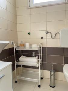 a bathroom with a towel rack and a sink at Seaside apartments in Kaštela