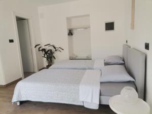 Studio Luna في بال: سريرين في غرفة نوم بيضاء مع طاولتين