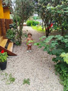 a little girl sitting in the middle of a garden at ГРАНАТОВЫЙ ДВОРИК-Домики in Alakhadzi