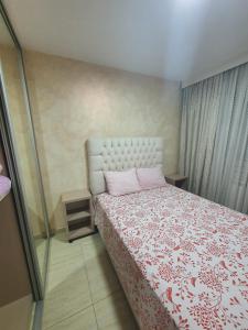 Schlafzimmer mit einem Bett mit einer roten und weißen Decke in der Unterkunft Apartman KRISTINA,Istocno Sarajevo,Vojvode Radomira Putnika 49D in Sarajevo