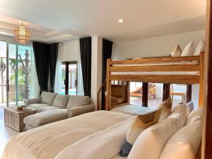 a bedroom with a large bed and a couch at Villa Vara - Tropical Pool Villa in Ao Nang Beach