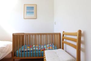 a crib and a chair in a bedroom at Grijpskerkseweg 3 achterhuis in Oostkapelle