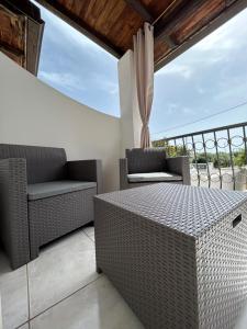 een patio met rieten stoelen en een tafel bij Casa Mario e Rosa in Orosei