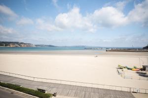 a beach with boats on the sand and the water at Hôtel de la Baie in Crozon