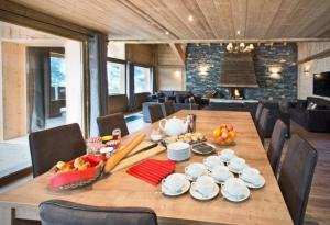 a wooden table with plates and bowls of food on it at Chalet Kalliste spacieux Meribel 5 min des pistes avec Spa in Les Allues