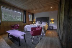 1 dormitorio con 1 cama, 2 sillas y ventana en Chalet Kalliste spacieux Meribel 5 min des pistes avec Spa en Les Allues