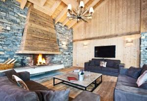 sala de estar con sofá y chimenea en Chalet Kalliste spacieux Meribel 5 min des pistes avec Spa en Les Allues