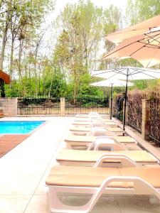 a row of lounge chairs with umbrellas next to a pool at Park and pool Studio Apostolovi in Nesebar