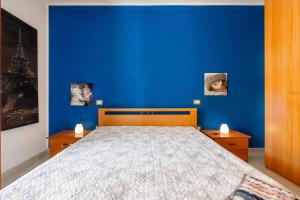 una camera da letto blu con un letto con una parete blu di L Oasi della gatta panciona a Villasimius