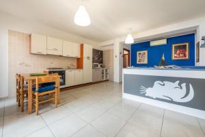 una cucina con un tavolo e una sala da pranzo di L Oasi della gatta panciona a Villasimius